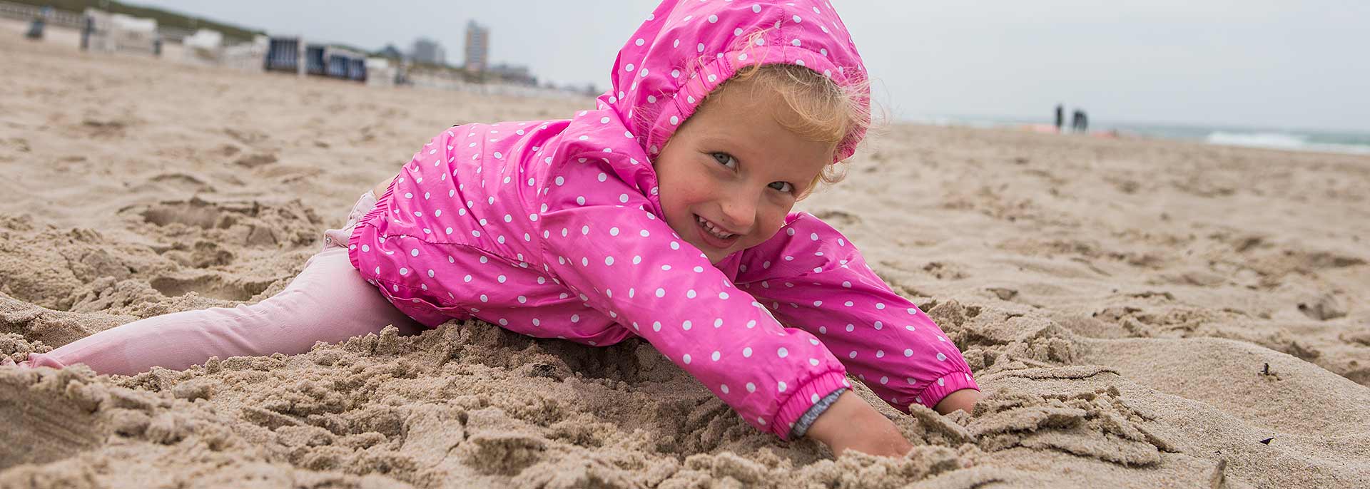 Kind buddelt im Sand am Strand 